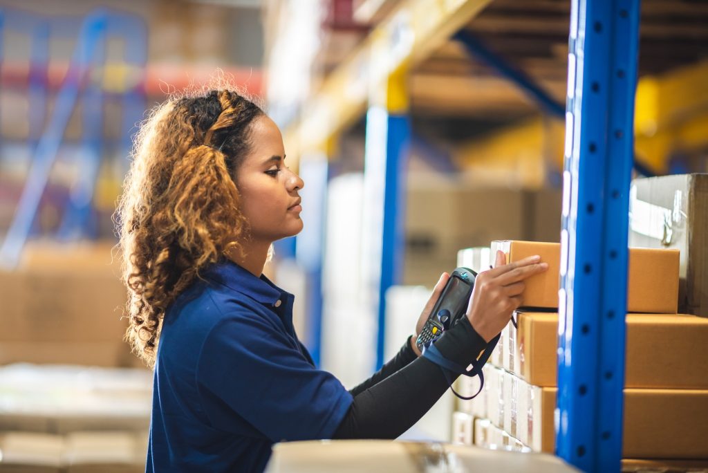 African American woman are work with business distribution inventory in warehouse factory